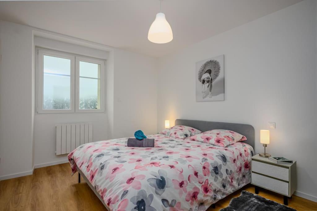 - une chambre avec un lit doté d'un couvre-lit floral et d'une fenêtre dans l'établissement Le Belvédère du Lac Blanc, à Orbey