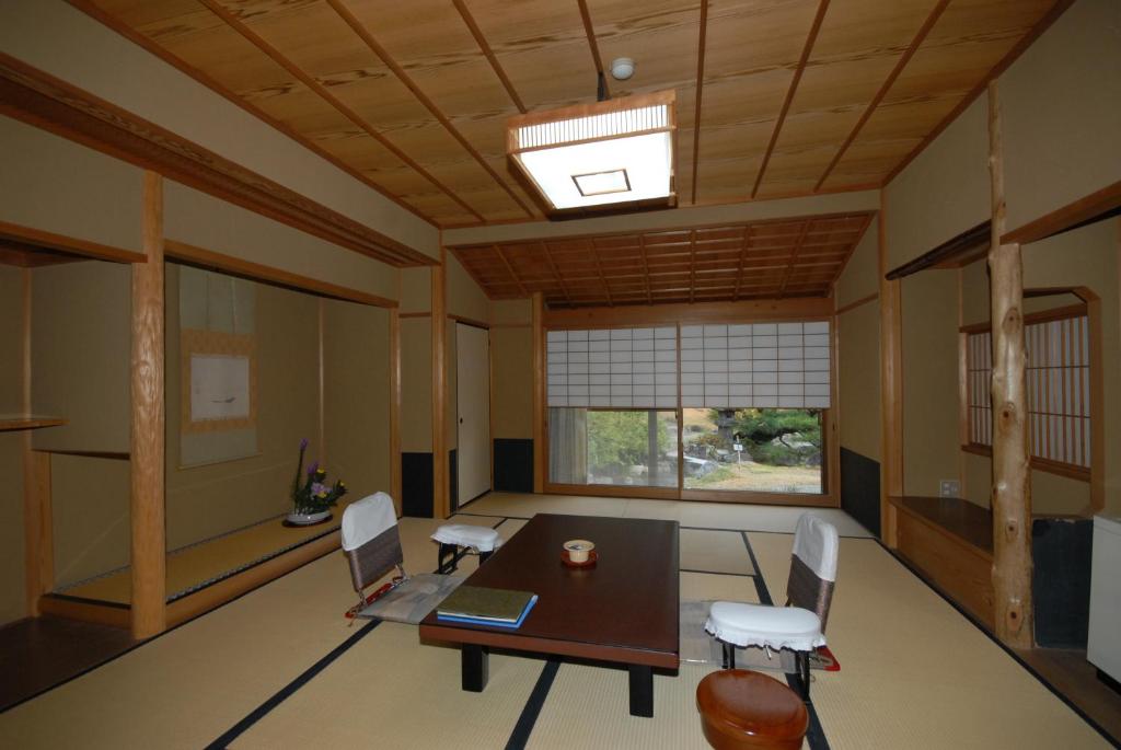 une pièce avec une table, des chaises et une fenêtre dans l'établissement Sansuien, à Yamaguchi