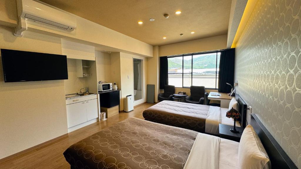 une chambre d'hôtel avec deux lits et une cuisine dans l'établissement Yufuin Akarinoyado, à Yufu
