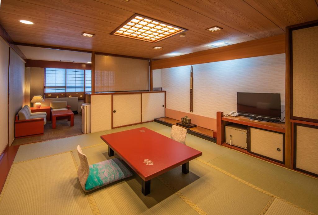 un salon avec une table et une télévision dans l'établissement Kinugawa Park Hotels, à Nikkō