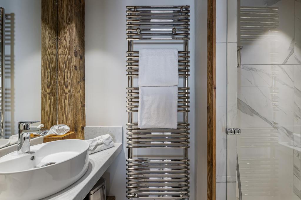 une salle de bain avec un lavabo blanc et une douche dans l'établissement Appartement Blanchot - LES CHALETS COVAREL, à Val dʼIsère
