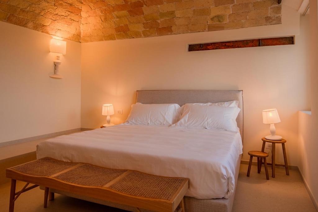 une chambre avec un grand lit blanc avec deux lampes dans l'établissement Moliké country house, à Giulianova