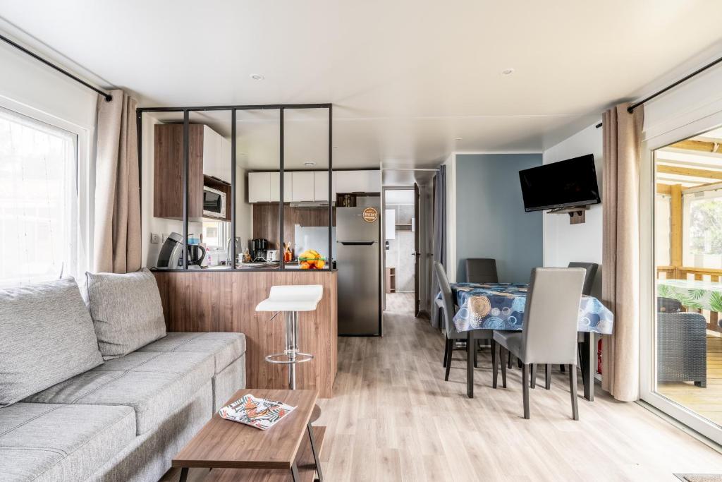 un salon et une cuisine avec un canapé et une table dans l'établissement Mobil-home Saint Jean de Monts, à Saint-Jean-de-Monts