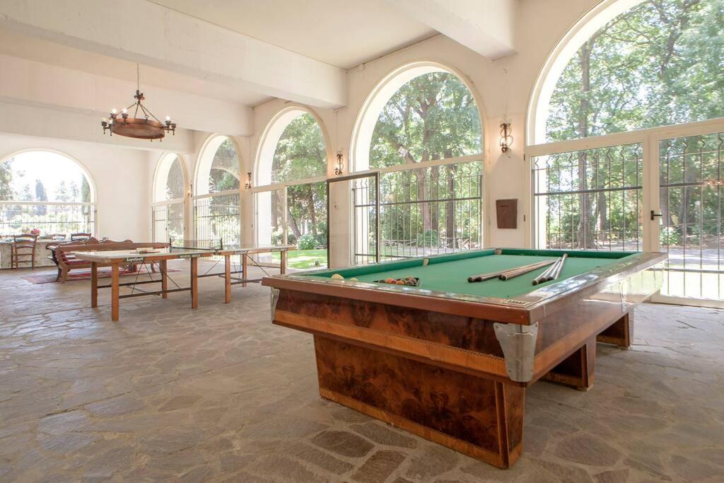 une grande salle avec des tables de billard et des fenêtres dans l'établissement Tenuta la Valle Relaxing Oasis with pool in Tuascany, à Vada