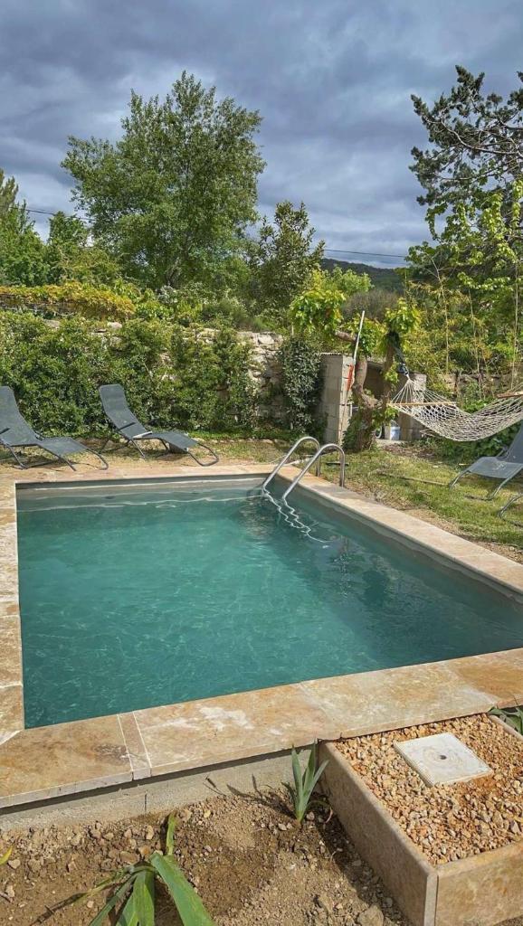 une piscine dans une cour avec dans l'établissement Gîte des Bourboul, à Grospierres