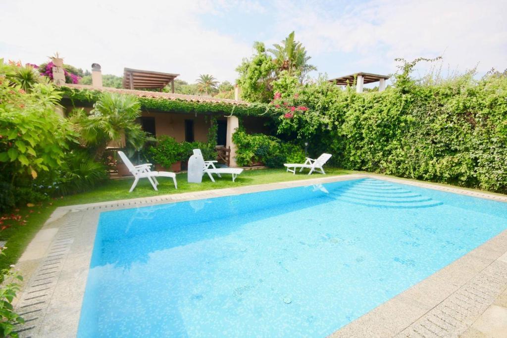 une piscine devant une maison dans l'établissement Villa Daina Liscia di Vacca, à Liscia di Vacca