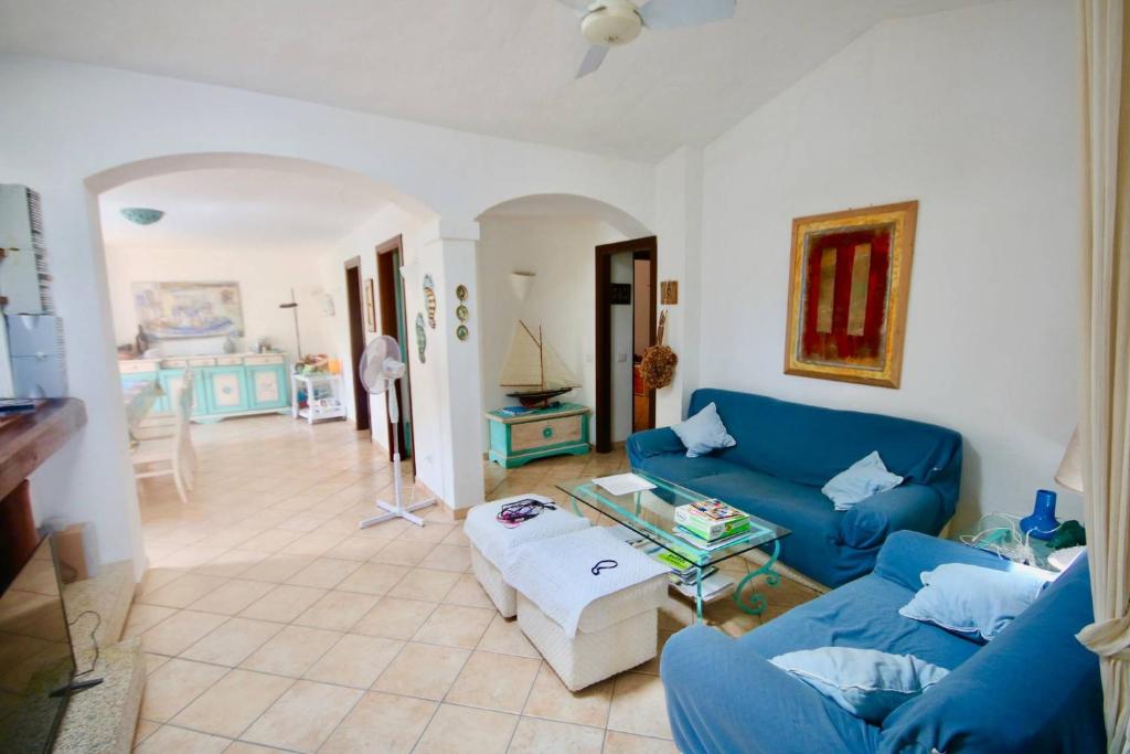 un salon avec un canapé bleu et une table dans l'établissement Villa Daina Liscia di Vacca, à Liscia di Vacca