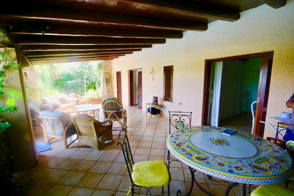 Cette chambre dispose d'une terrasse avec une table et des chaises. dans l'établissement Villa Daina Liscia di Vacca, à Liscia di Vacca