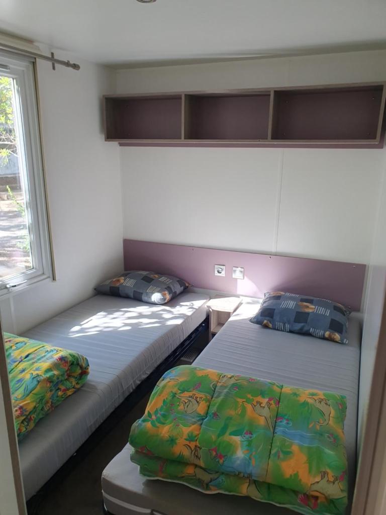 une chambre avec deux lits et une fenêtre dans l'établissement Chalet Coco, à Roquebrune-sur Argens 36 autres photos