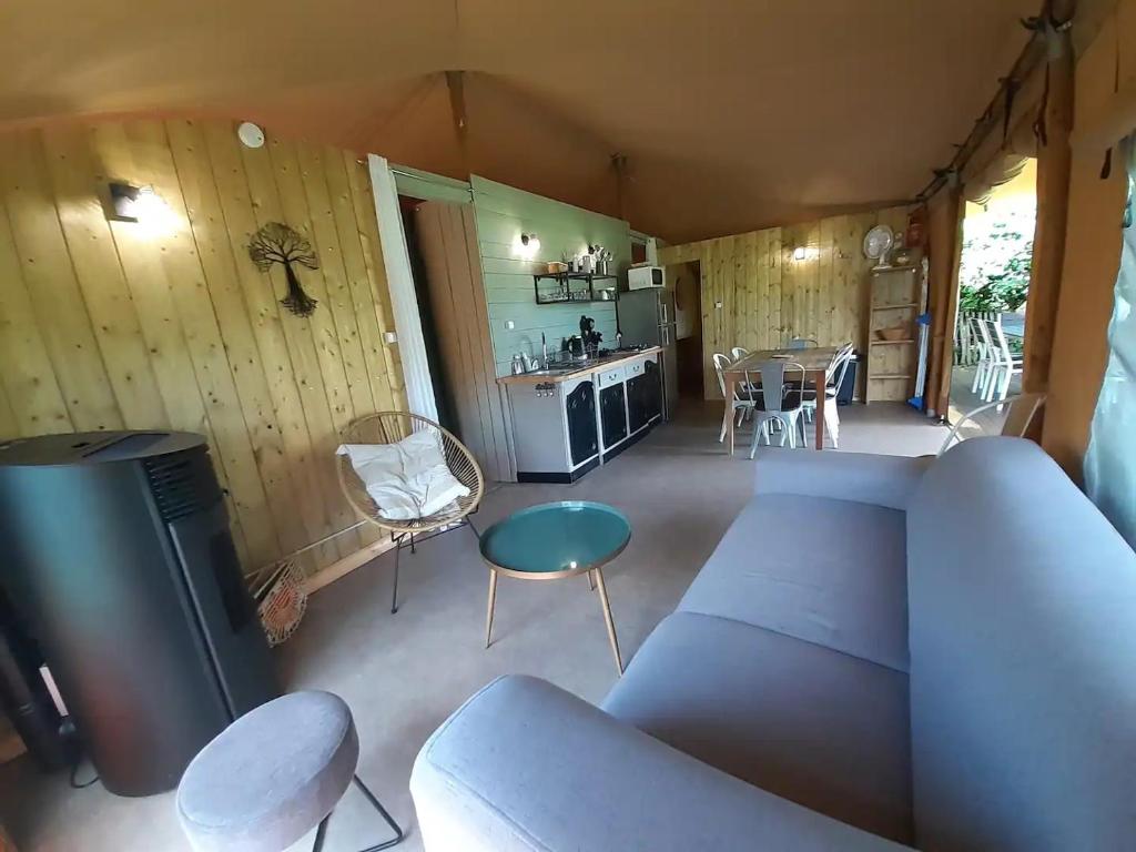 un salon avec un canapé et une table dans l'établissement Lodge Nature à Vigeois, à Vigeois