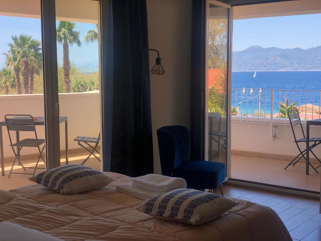 une chambre avec un lit et une vue sur l'océan dans l'établissement Thalassa Suite & Spa, à Reggio de Calabre