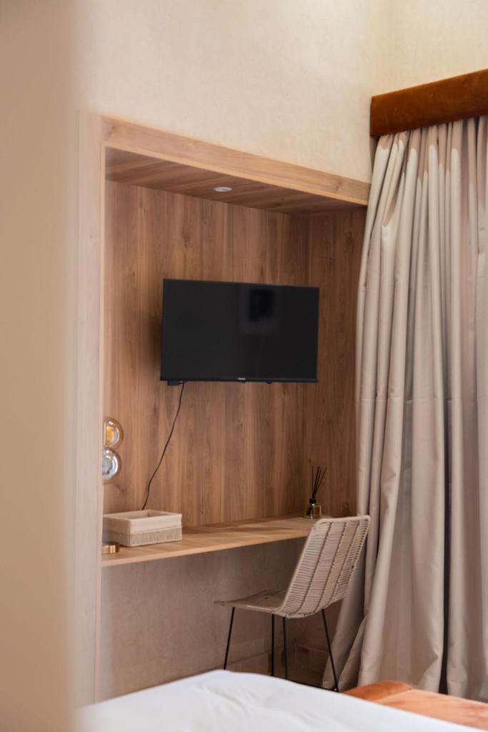 Cette chambre comprend un lit et une télévision murale. dans l'établissement Maison Nalos, à Marrakech