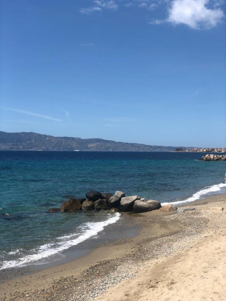 un groupe de rochers dans l'eau sur une plage dans l'établissement Thalassa Suite & Spa, à Reggio de Calabre