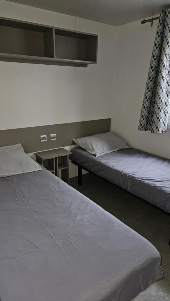 une chambre avec deux lits et une table dans l'établissement Spacieux Mobil-home Num227 2 chambres, 2sdb à 2 pas du lac, à Gastes 8 autres photos