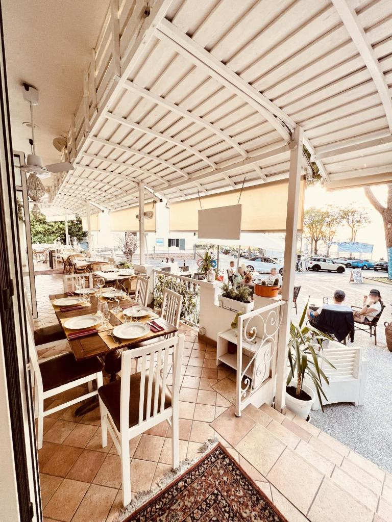 d'un coin repas extérieur avec une table et des chaises ainsi que d'une terrasse. dans l'établissement Hotel Everest - Bar e Ristorante, à Gabicce Mare