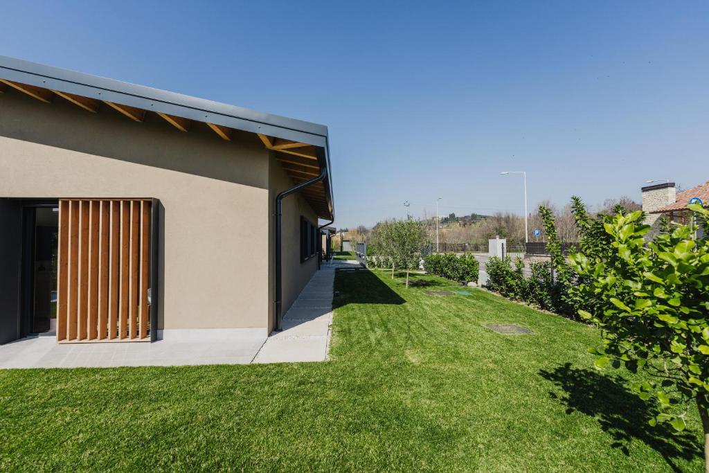 une maison avec une cour verdoyante à côté d'un bâtiment dans l'établissement Luxe Villa Maxime, à Lazise
