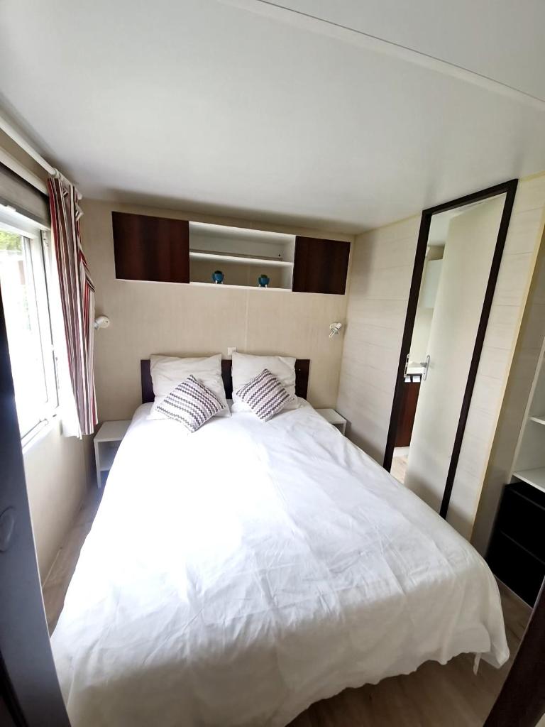 - un grand lit blanc avec deux oreillers dans une chambre dans l'établissement Mobilhome Labenne Océan, à Labenne