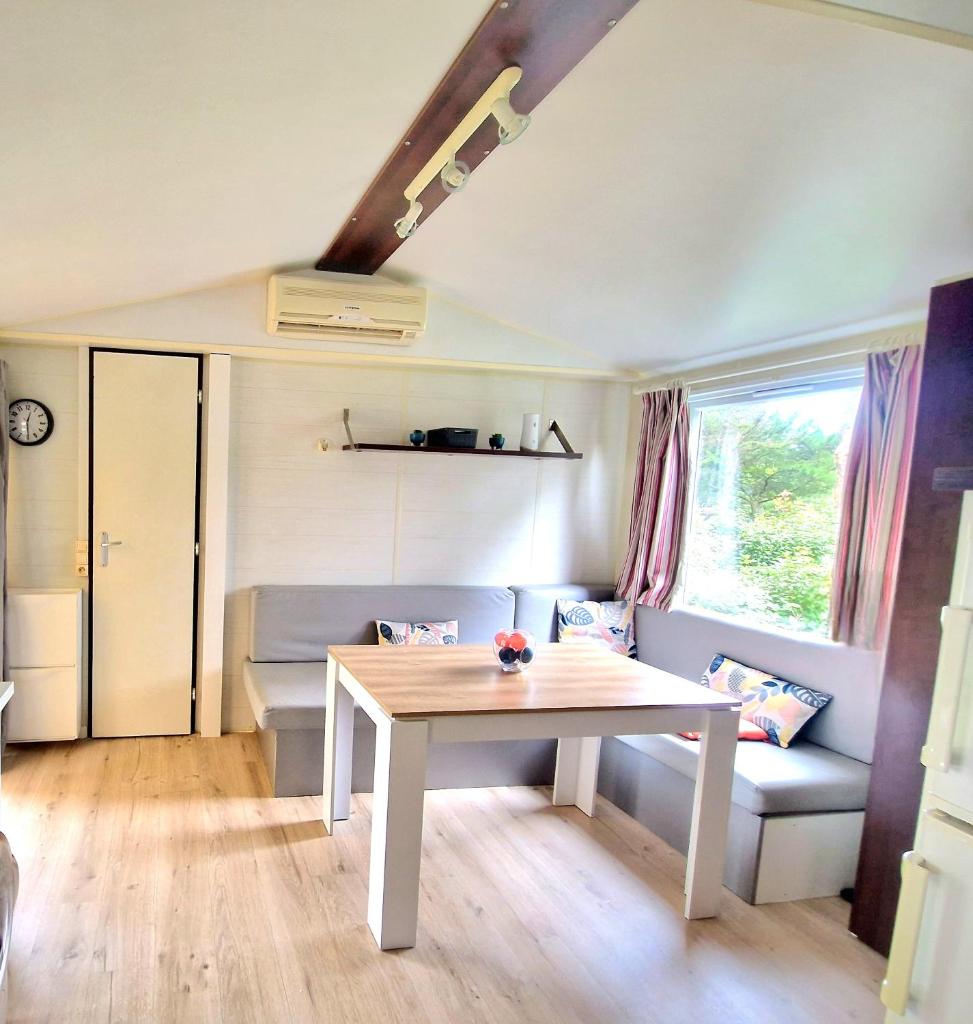 un salon avec une table et un canapé dans l'établissement Mobilhome Labenne Océan, à Labenne
