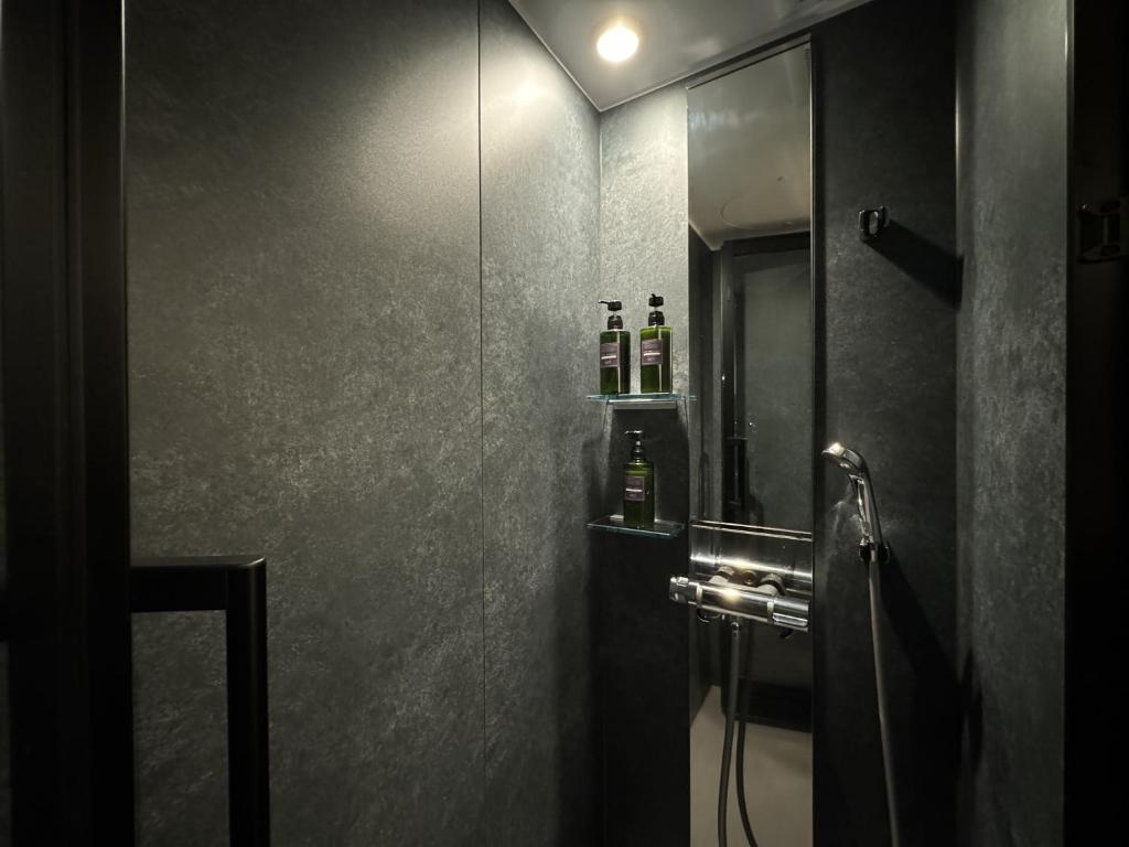 La salle de bains est pourvue d'une douche avec un miroir et un lavabo. dans l'établissement AKAMA Kamakura, à Kamakura