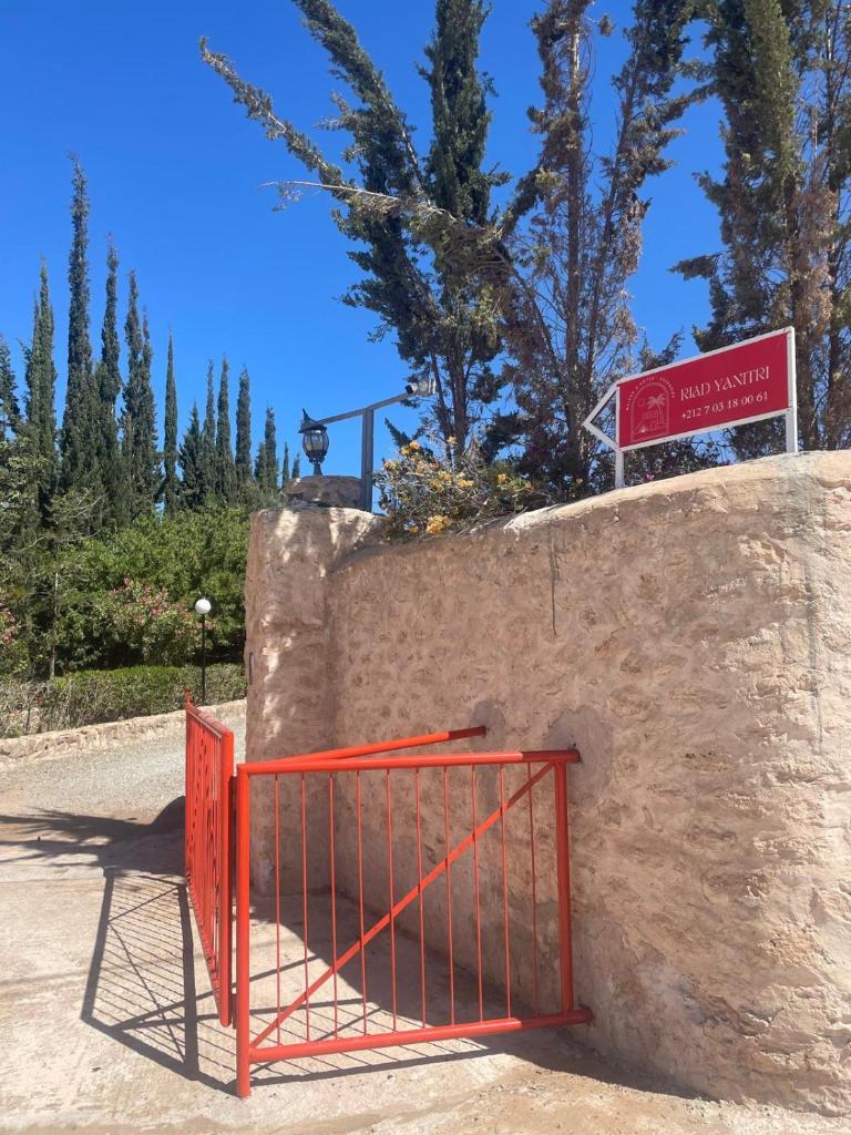 une porte rouge au sommet d'un mur de pierre dans l'établissement RIAD YANITRI Piscine chauffée, à Essaouira