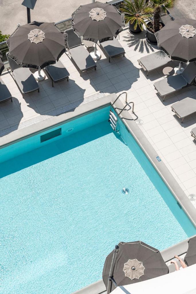une vue aérienne d'une piscine avec parasols et chaises dans l'établissement Hotel Europa, à Lido di Jesolo