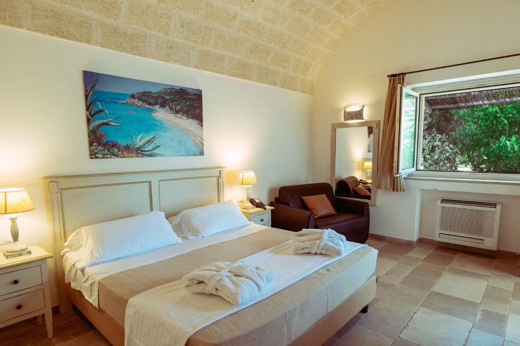 une chambre avec un lit, une chaise et une fenêtre dans l'établissement Casale del Murgese Country Resort, à Savelletri di Fasano
