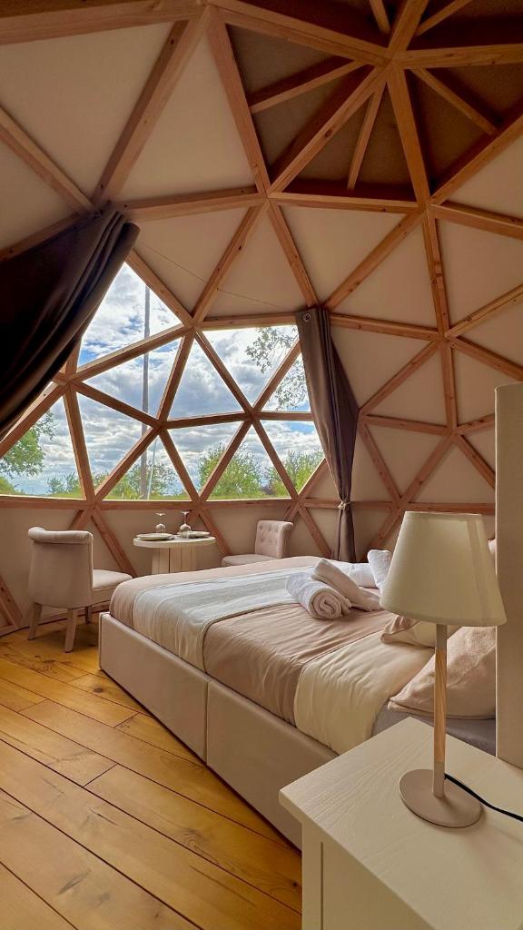 une chambre avec un grand lit dans une grande tente dans l'établissement Dôme Pathome, à Catonvielle