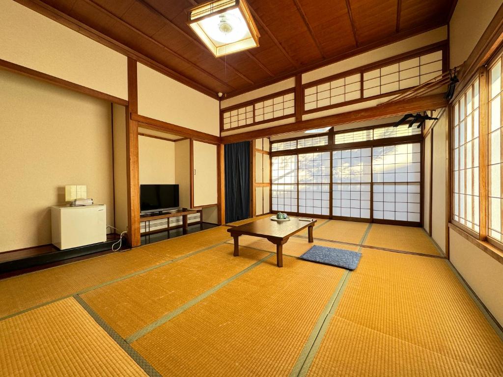 Cette grande chambre dispose d'une table et de fenêtres. dans l'établissement Shiroyamasou, à Asahi