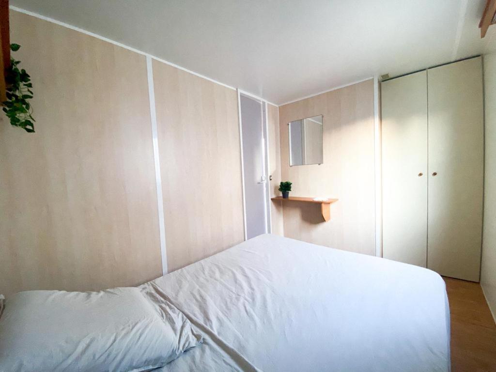 - une chambre avec un lit blanc et une armoire dans l'établissement Camping Europcamping, à Fréjus