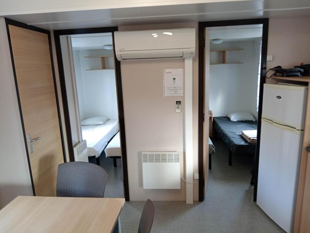 une petite chambre avec une cuisine et une chambre avec un lit dans l'établissement MOBIL HOME 6 Places - CLIMATISE, à Aureilhan