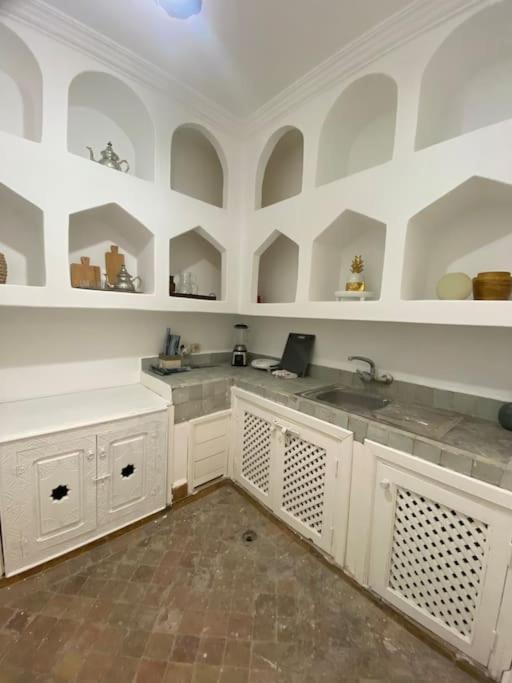 une cuisine avec des armoires blanches et un évier dans l'établissement Riad Fiora, private home!!!, à Marrakech