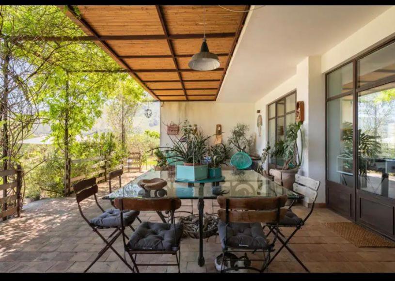 d'une terrasse avec une table et des chaises en verre. dans l'établissement VILLA AZUL, à Castellammare del Golfo