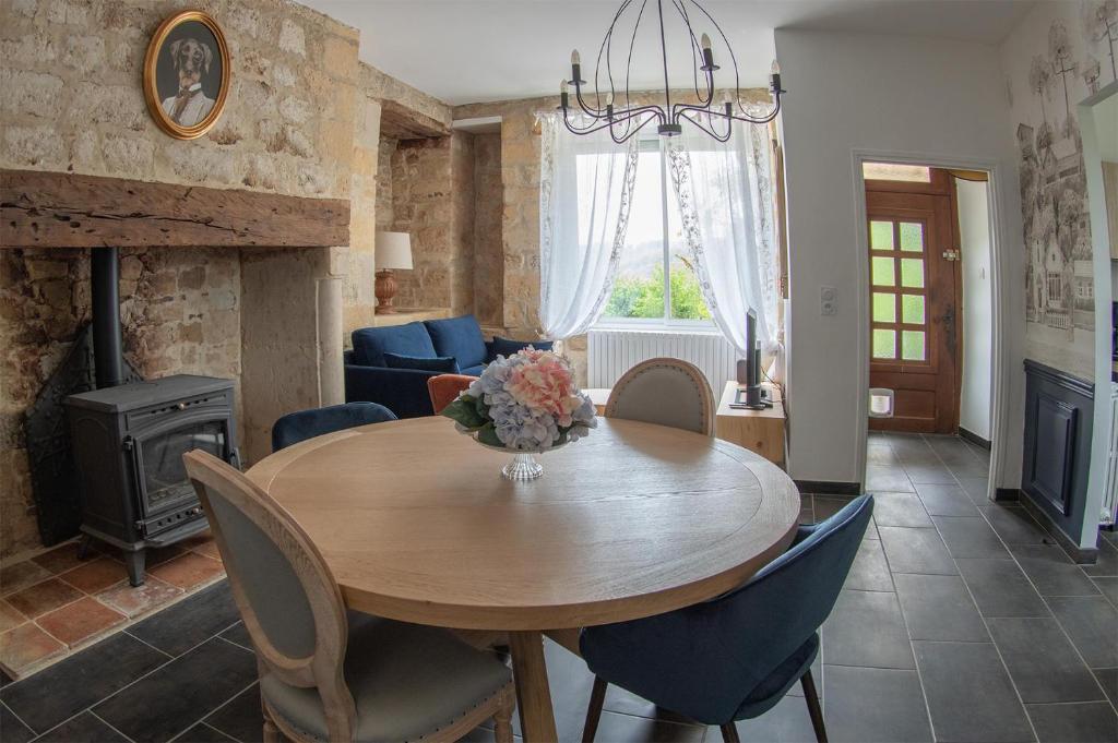 une salle à manger avec une table, des chaises et une cheminée dans l'établissement Les Gîtes de la Vallée du Céou, à Gourdon