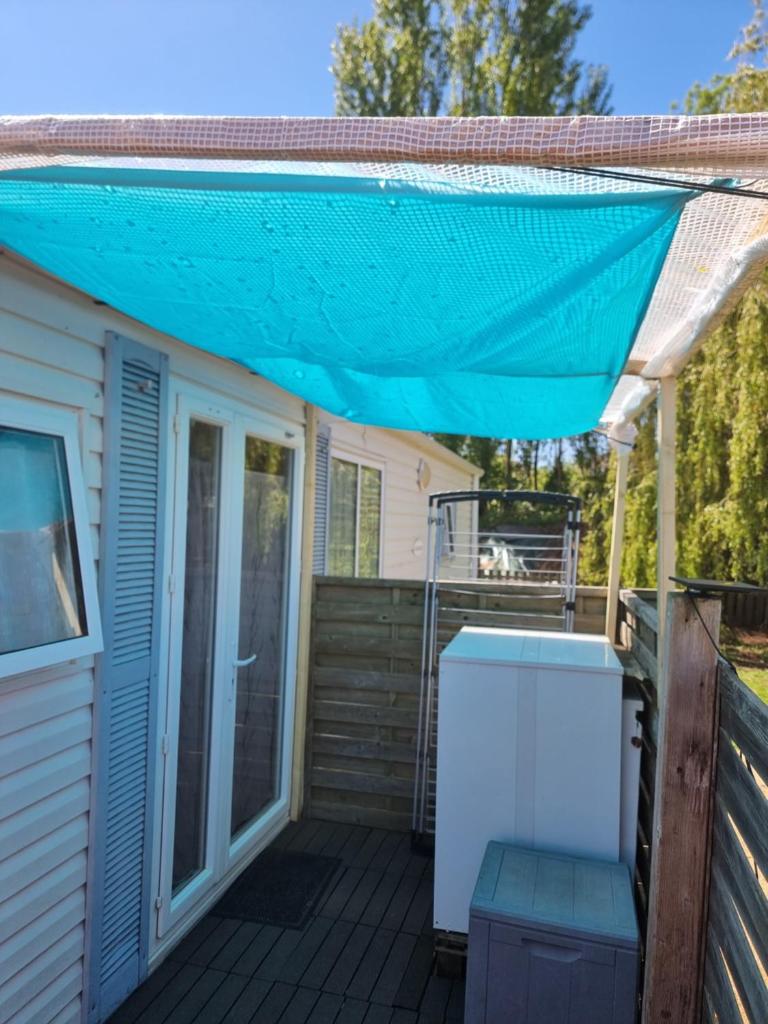 auvent sur une terrasse avec une maison dans l'établissement Mobil home chez l habitants, à Saint-Jean-de-Monts
