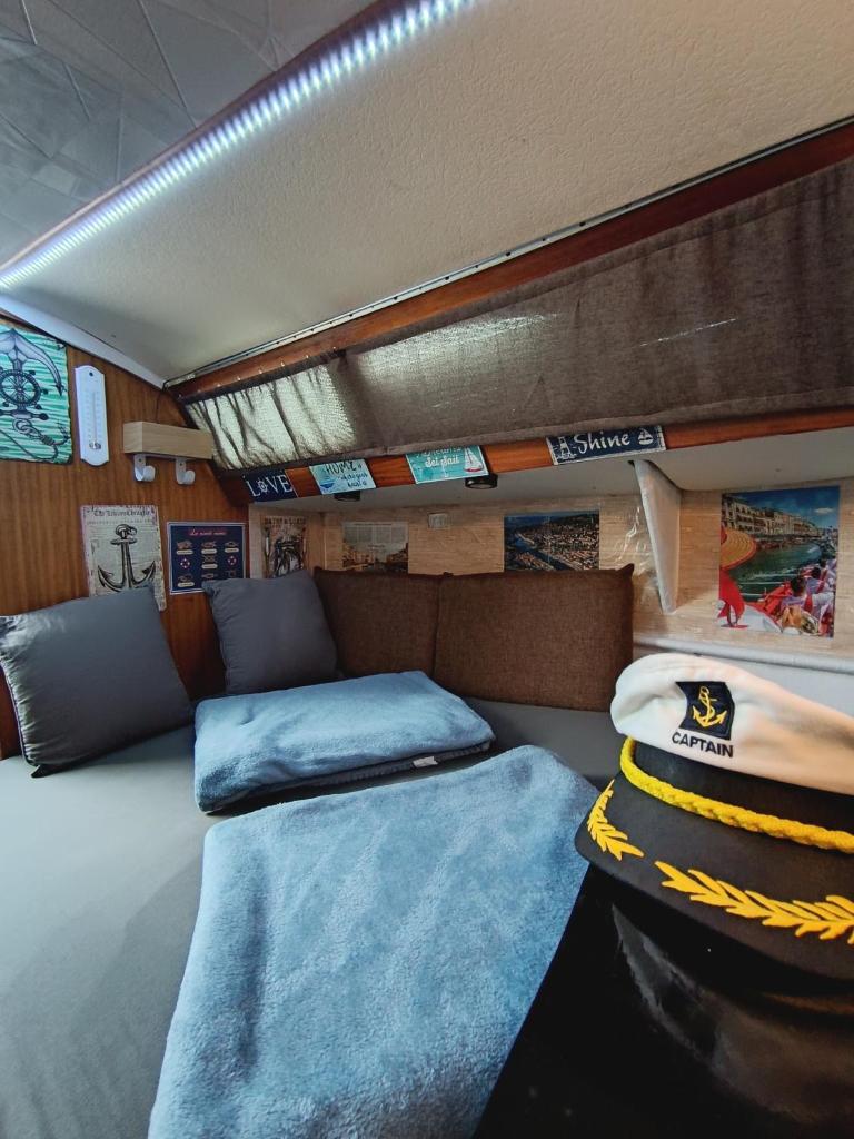 Cette chambre comprend un lit et un canapé. dans l'établissement Le Nid Marin,Un Voilier Pour Deux Sète Vieux Port, à Sète