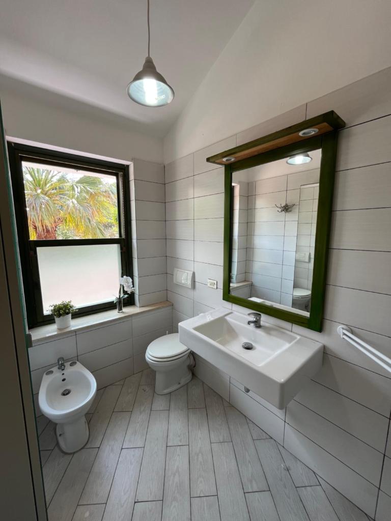 une salle de bain avec un lavabo, des toilettes et un miroir dans l'établissement La casa al Rais, à Finale