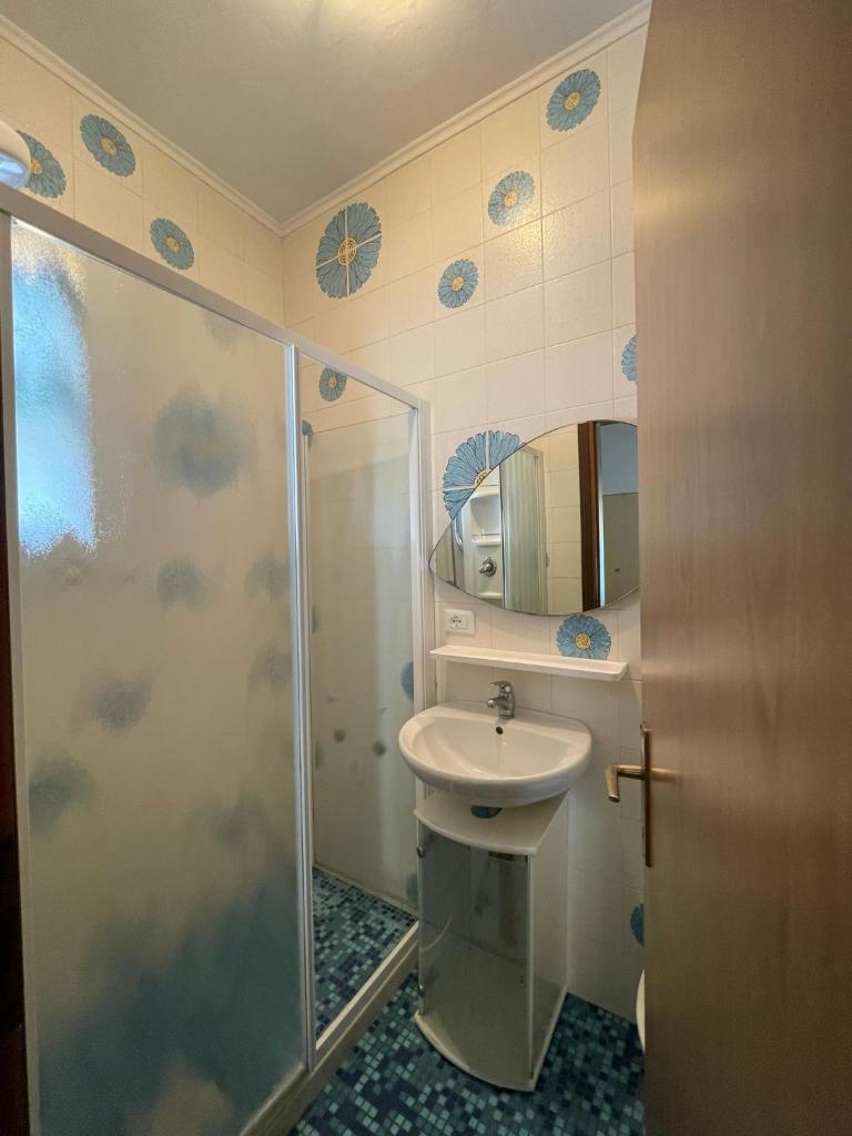 une salle de bain avec douche et lavabo dans l'établissement Appartamenti Residence Foscolo, à Lido di Jesolo