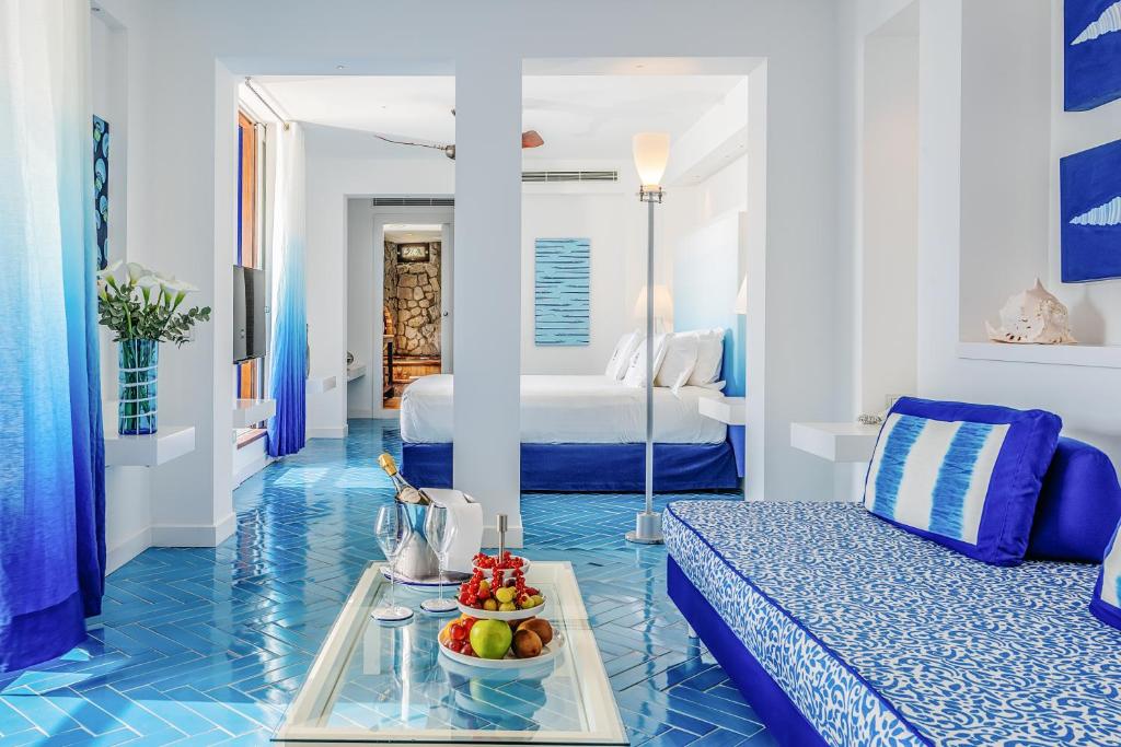 une chambre bleue et blanche avec un lit et un plateau de fruits dans l'établissement Capo la Gala Hotel&Wellness, à Vico Equense