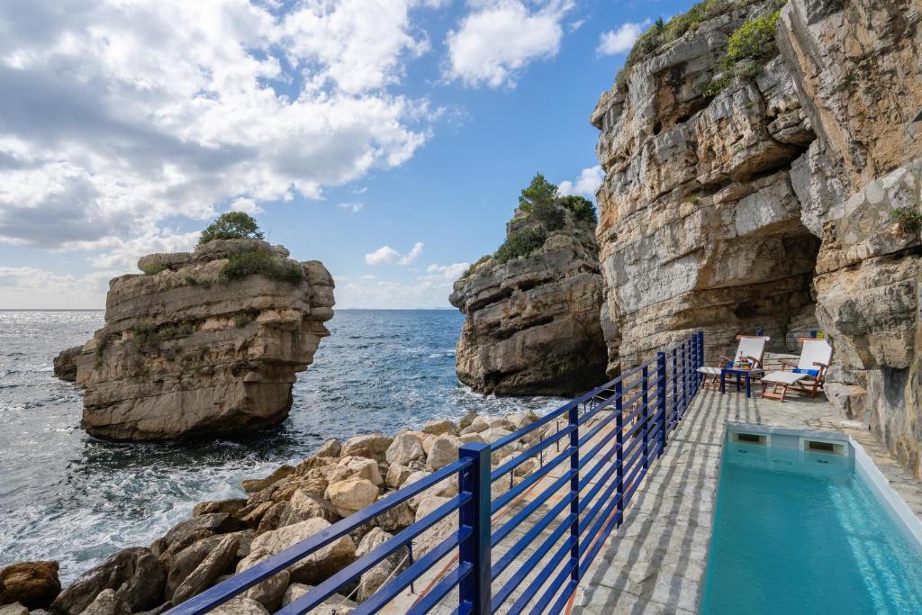 - une piscine avec des rochers à côté de l'océan dans l'établissement Capo la Gala Hotel&Wellness, à Vico Equense