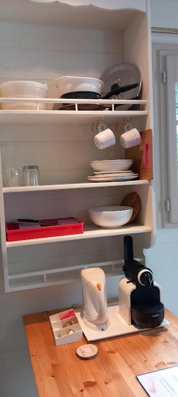 - une cuisine avec des assiettes et des ustensiles sur les étagères dans l'établissement Villa Rose La Belle Roulotte, à Escolives-Sainte-Camille