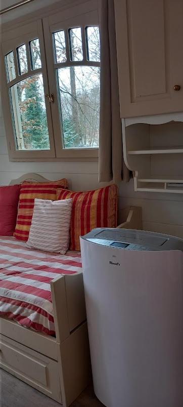 Cette petite chambre comprend un lit et un réfrigérateur. dans l'établissement Villa Rose La Belle Roulotte, à Escolives-Sainte-Camille