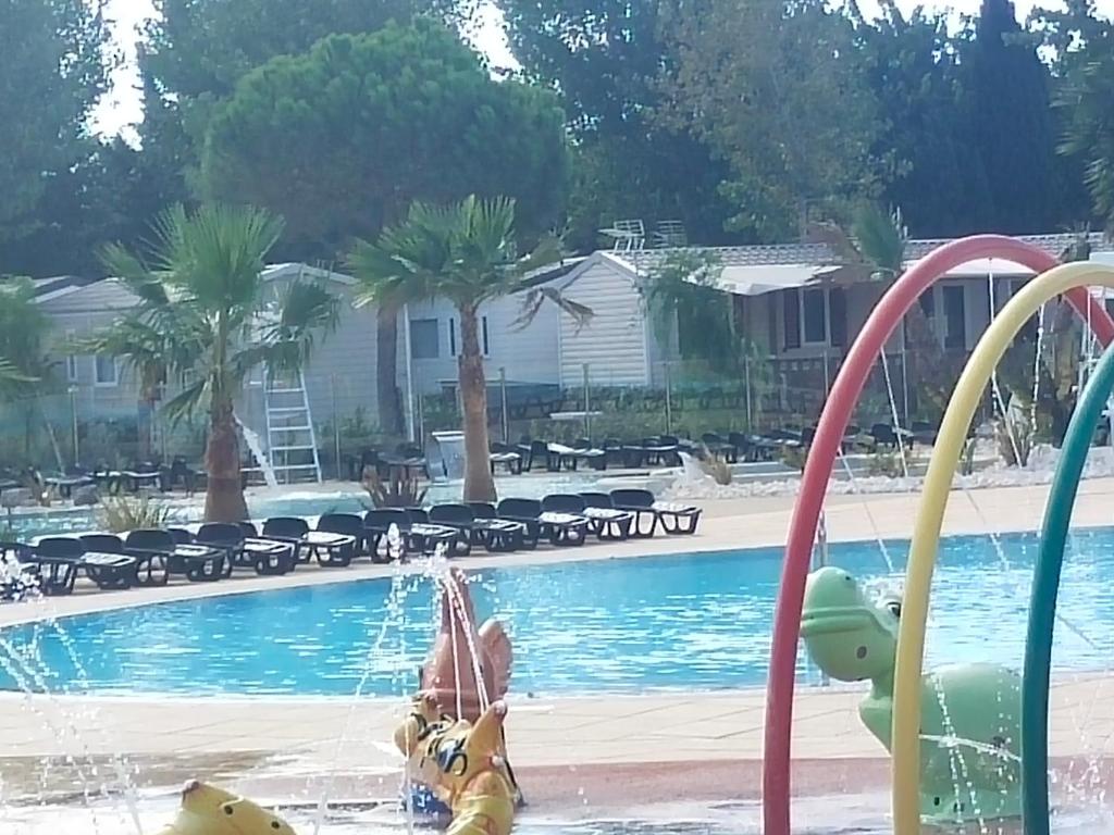 un enfant jouant dans l'eau à la piscine dans l'établissement MOBIL HOME LE COCOONING, à Valras-Plage 37 autres photos