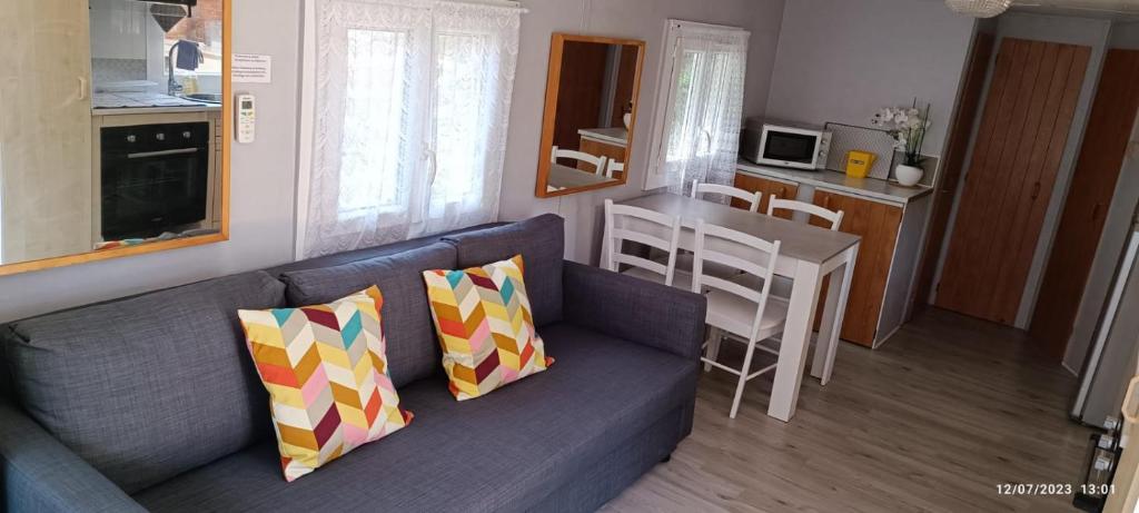 un salon avec un canapé bleu et une cuisine dans l'établissement Havre de paix pour 2 à 4 pers., au Castellet