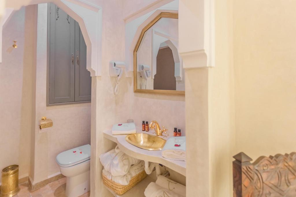 une salle de bain avec un lavabo et des toilettes dans l'établissement Riad Luxe Nomade Marrakech & Spa, à Marrakech