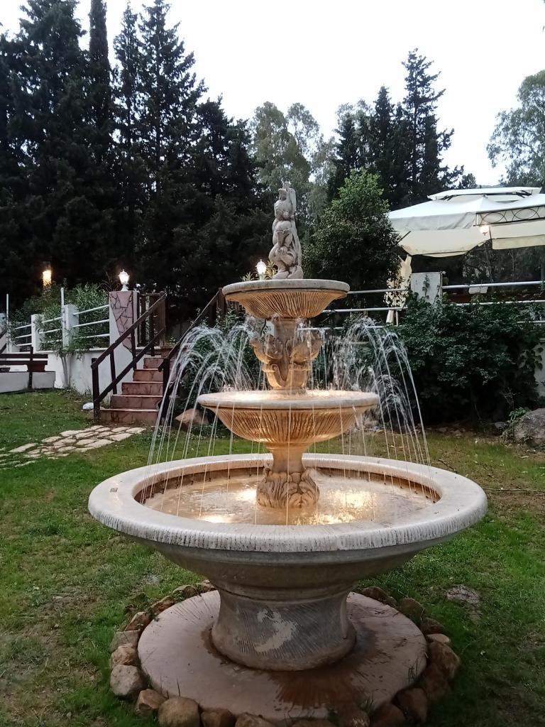 une fontaine au milieu d'une cour dans l'établissement VILLA STRAVANATA - Large Pool, Car and Large Whirlpool Jacuzzi, à San Gregorio