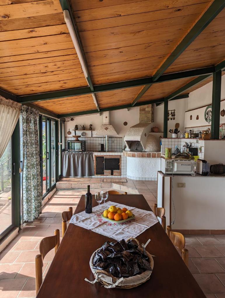 une cuisine avec une table avec un bol de fruits dessus dans l'établissement Villa Artemis, à Graniti