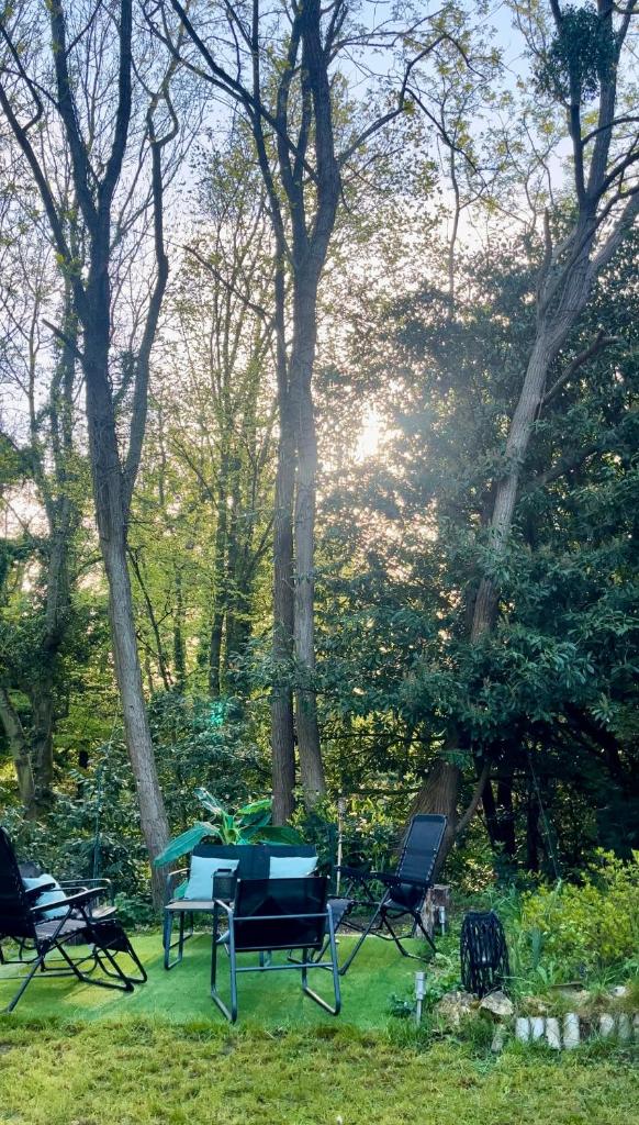 un groupe de chaises assises sur l'herbe dans un parc dans l'établissement Tiki House M-Home-Climatisé - Belle parcelle !, à Saint-Chéron