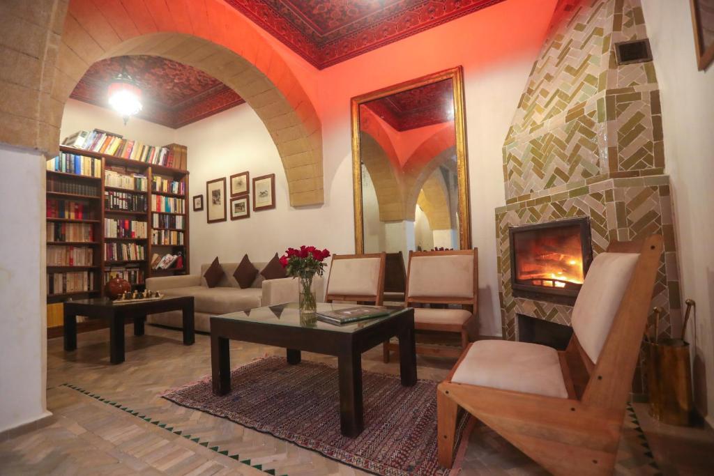 un salon avec une table et une cheminée dans l'établissement Riad Perle D'Eau, à Essaouira