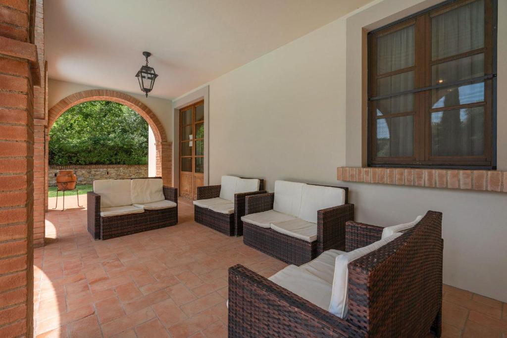d'une terrasse avec des chaises et des tables en osier et une fenêtre. dans l'établissement Villa Salvucci With Private Pool In San Gimignano, à San Gimignano