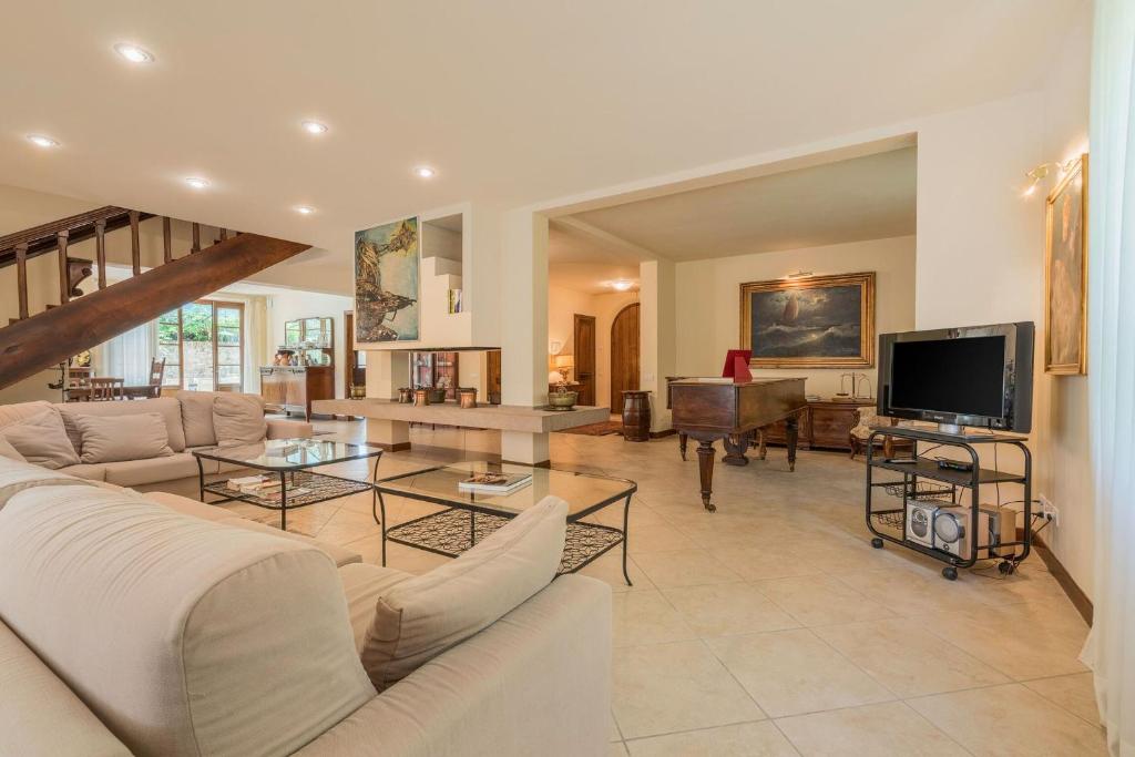 un salon avec un canapé et une télévision dans l'établissement Villa Salvucci With Private Pool In San Gimignano, à San Gimignano